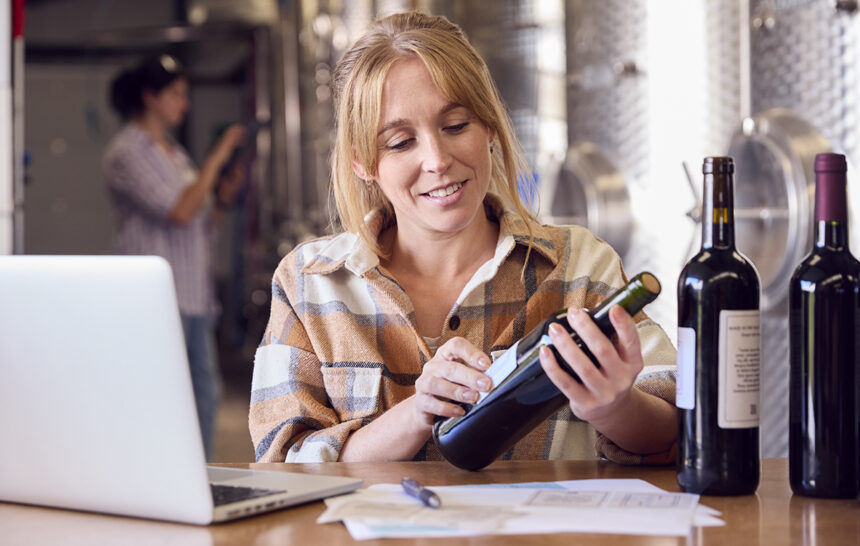 woman-with-laptop-checking-label-on-bottle-inside come funziona etichetta digitale